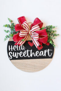 This shows a completed DIY Valentine's Day wreath made out of a wood round.