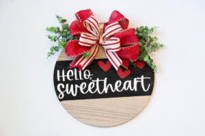 This shows a completed DIY Valentine's Day wreath made out of a wood round.