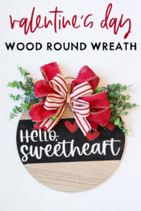 At the top, the image says Valentine's Day wood round wreath. Below that it shows an image of the completed DIY Valentine's Day wreath made out of a wood round.