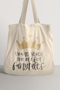 This image shows a tote bag with the you're never too old for fairy tales SVG file you can get for free in this post.