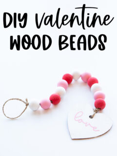 At the top it says DIY Valentine wood beads. Below that, the image shows the final DIY Valentine wood beads with a wood heart painted in white that says love in cursive in pink on it.