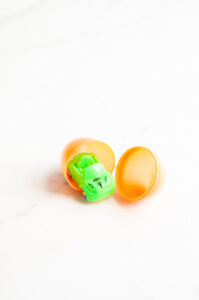 This image shows a plastic easter egg filled with non candy item of a pullback car.