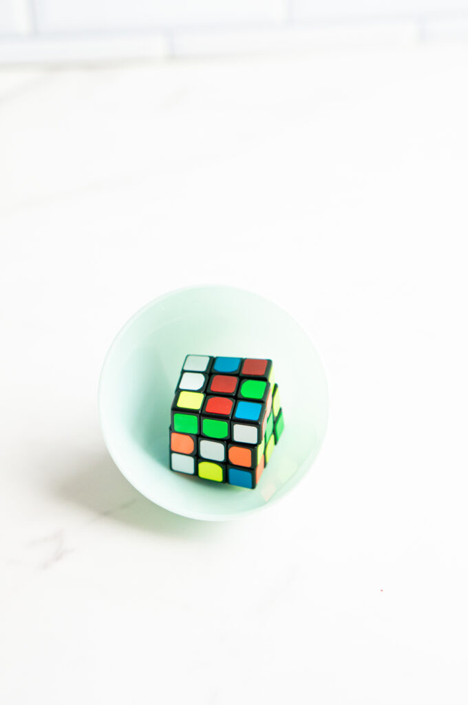 This image shows a plastic easter egg filled with non candy item of a mini rubix cube.