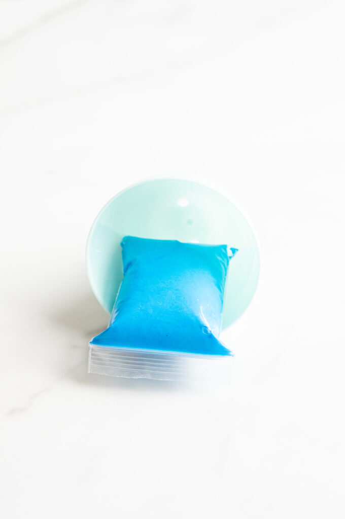 This image shows a plastic easter egg filled with non candy item of modeling clay.