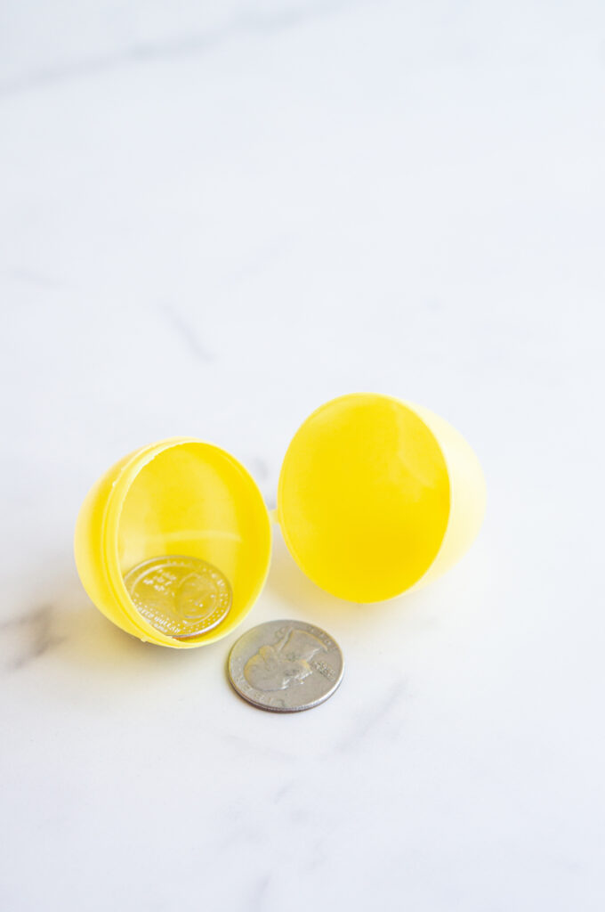 This image shows a plastic easter egg filled with non candy item of coins.
