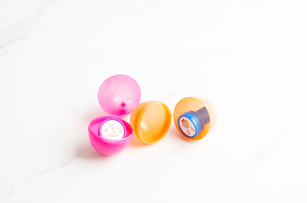 This image shows a plastic easter egg filled with non candy item of stampers.