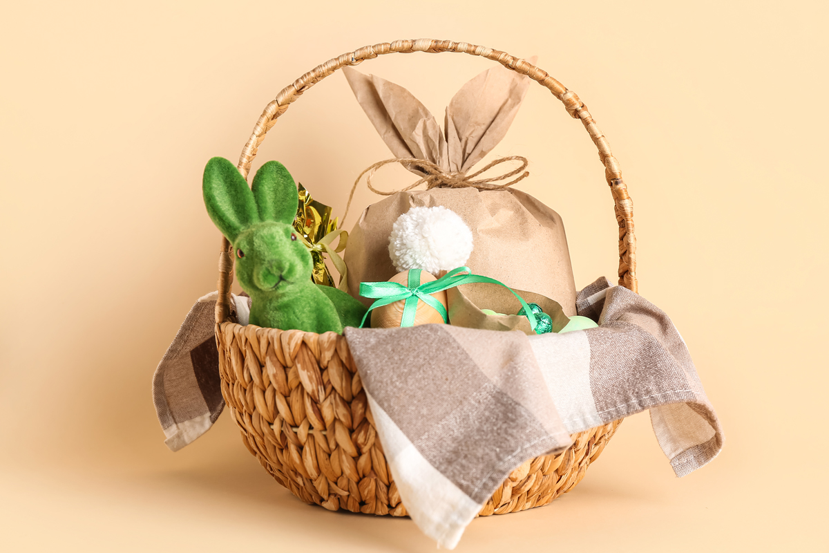 This is an image of an Easter basket filled with Easter decor, Easter eggs, and some treats.
