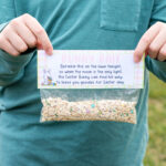 This image shows a boy holding up one of finished free bunny bait printable tags on top of a bag.