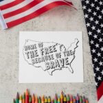 This Memorial Day coloring page has an outline of the United States of America (minus Hawaii and Alaska). Inside of the country, it says Home of the Free because of the Brave. Below the coloring page are some color pencils. Above that is an American flag.