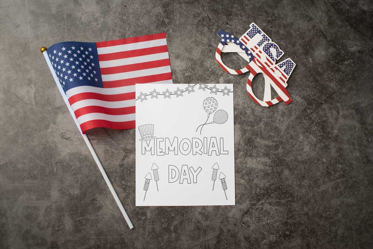 This This Memorial Day coloring sheet features the words Memorial Day with some balloons, a patriotic hat, firecrackers, and a star banner. To the top left of the coloring page is an American flag and the top right are some patriotic glasses.