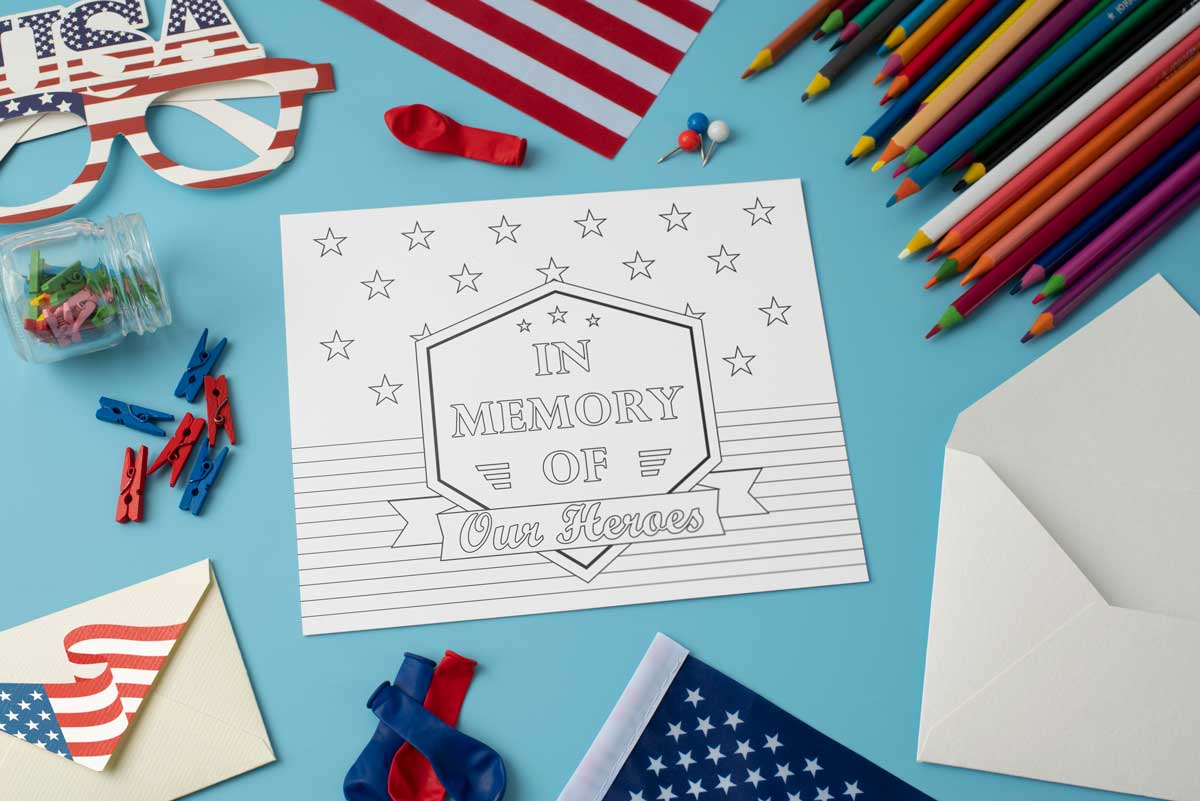 This This Memorial Day coloring sheet says In Memory of our Heroes. In addition, it has stars and stripes. The coloring page is surrounded by colored pencils and some patriotic items.