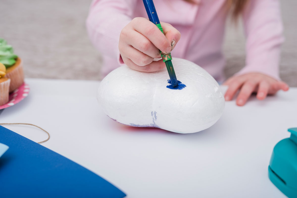 This image is showing one of the birthday party gift bag ideas which is a craft a child is painting to take home in place of a goody bag.