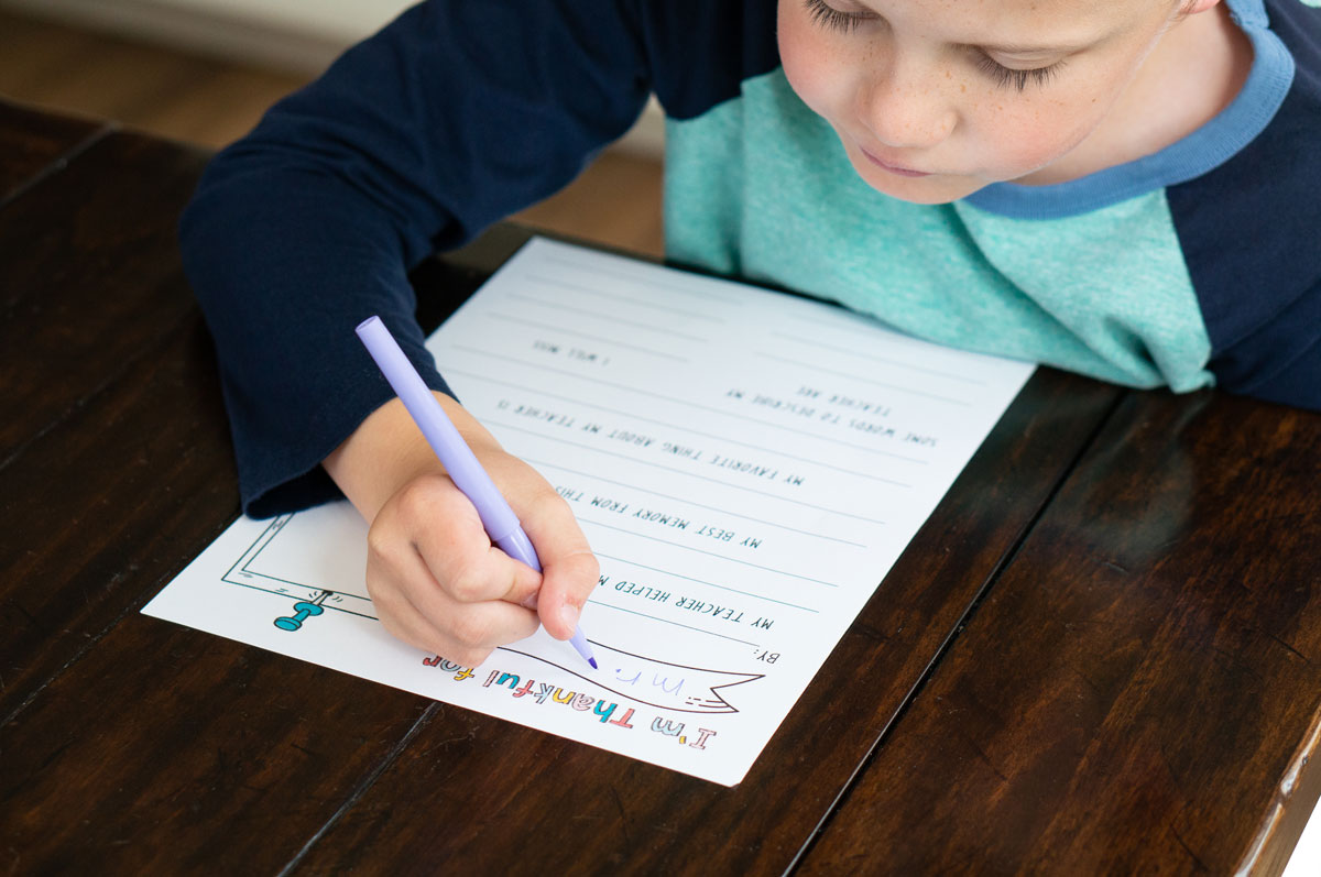 This image is of a child filling out the free printable teacher appreciation questionnaire you can download at the end of this post.