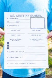 This is a picture of a child holding a Mother's Day all about my Grandma printable.