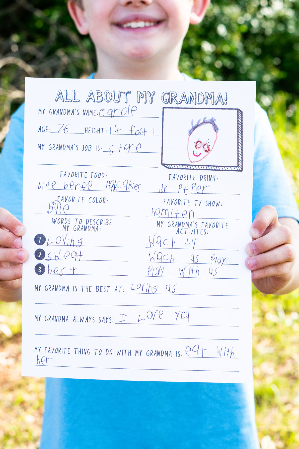 This is a picture of a child holding a Mother's Day all about my Grandma printable.