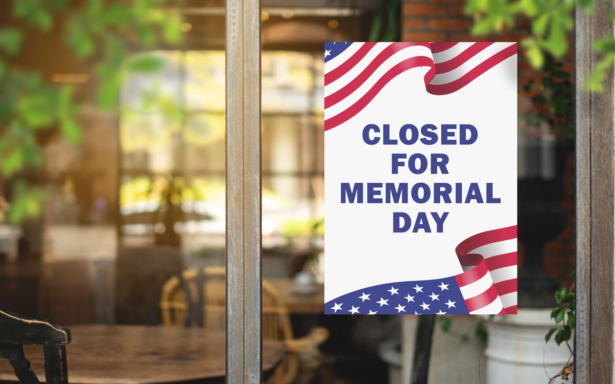 This image shows a free printable Closed for Memorial Day sign with a portion of the American flag in the upper left and bottom right hand corner.