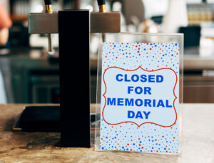 This image shows a free printable Closed for Memorial Day sign with the words surrounded by red and blue stars.