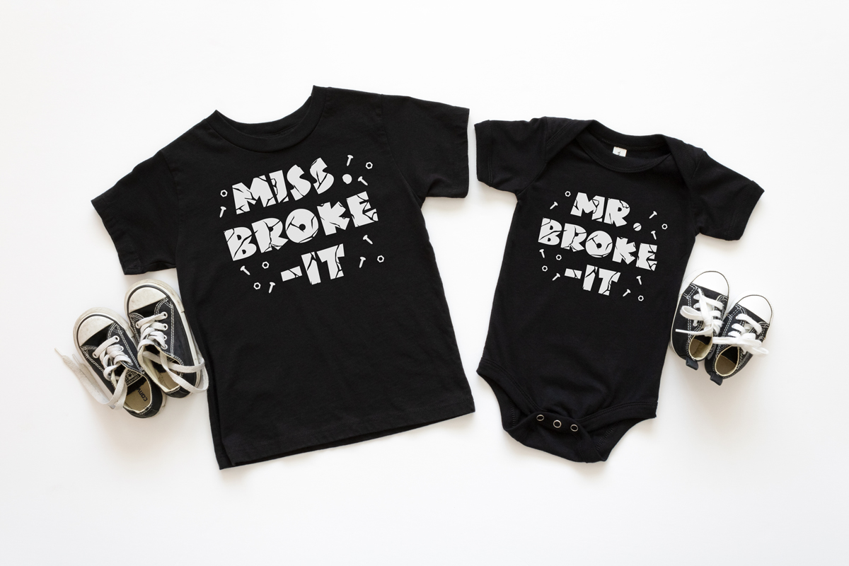 This is an image showing the two of the free SVGs from the Mr Fix It SVG set. It shows Miss Broke it and Mr Broke It displayed on a small toddler shirt and a onesie.