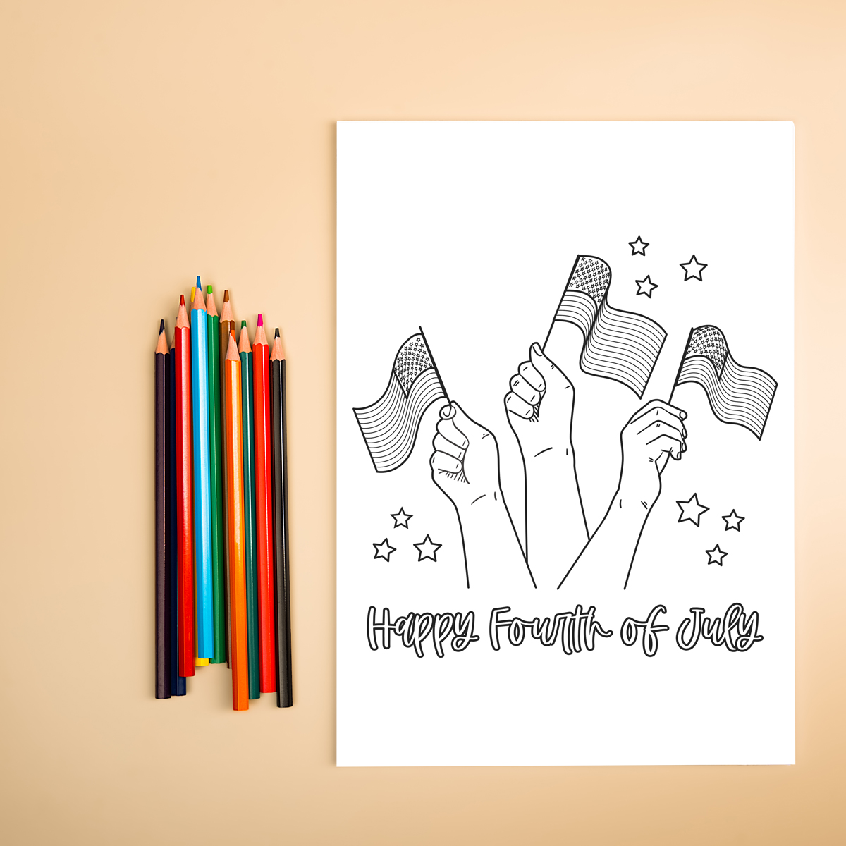 This image shows some colored pencils next to a free 4th of July coloring page printable. The coloring page says Happy Fourth of July and has three arms in the air holding small American flags.