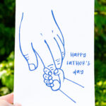 This card shows a larger relaxed hand with a tiny hand grabbing onto the pointer finger. It says Happy Father’s Day.