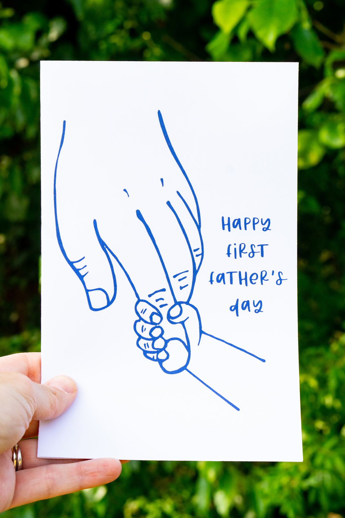 This card shows a larger relaxed hand with a tiny hand grabbing onto the pointer finger. It says Happy First Father’s Day.