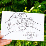 This card features a large hand fist pumping a small hand. It says Happy Father’s Day.