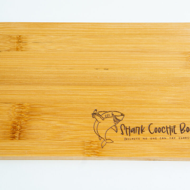 This is an image of a cutting board with the free Shark coochie board SVG engraved on it.