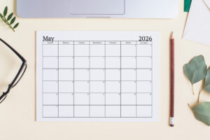 This image shows an example of the free 2026 calendar one page design you can get for free in this blog post. It's showing the month of May laying on a desk top.