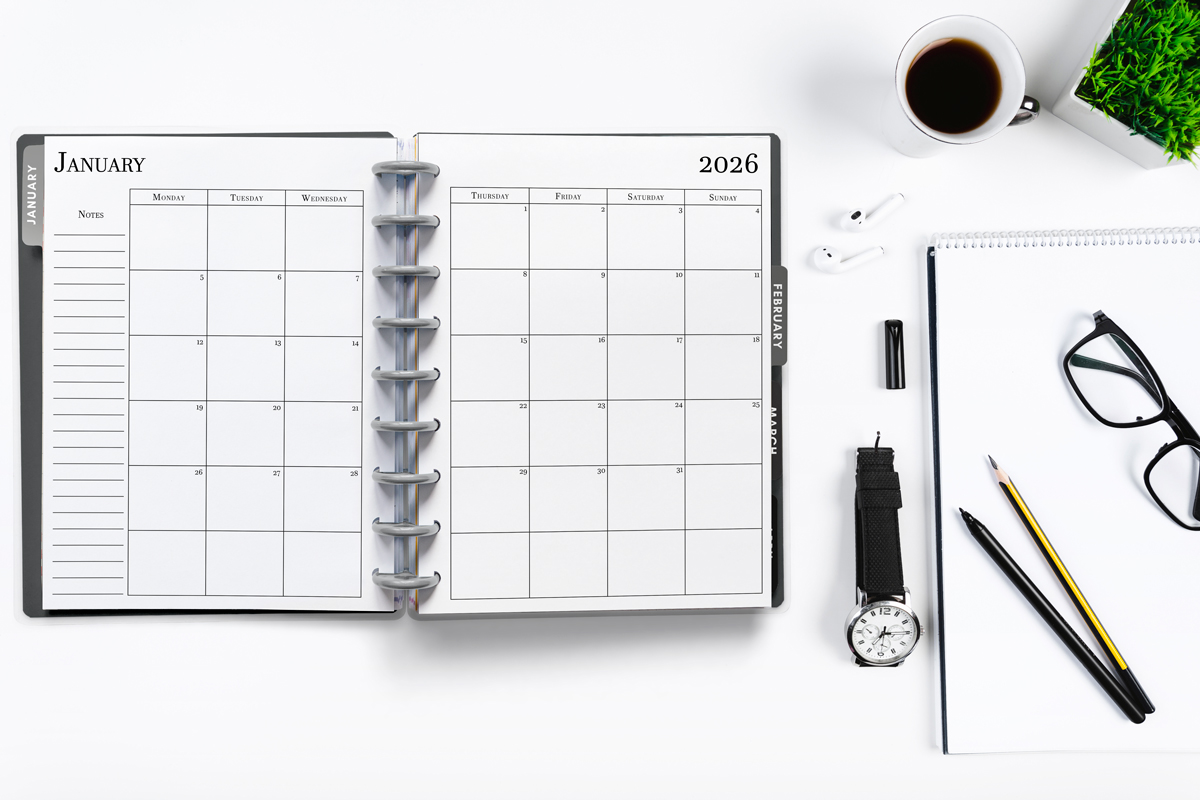 This image shows the 2026 free printable calendar you can download for free in this blog post. It is inside of an open planner on the month of January.