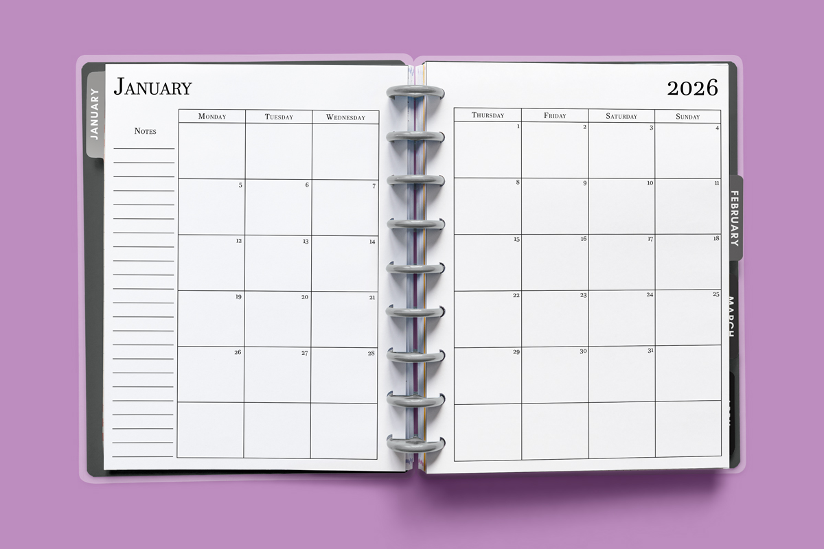 This image shows the 2026 free printable calendar you can download for free in this blog post. It is inside of an open planner on the month of January.