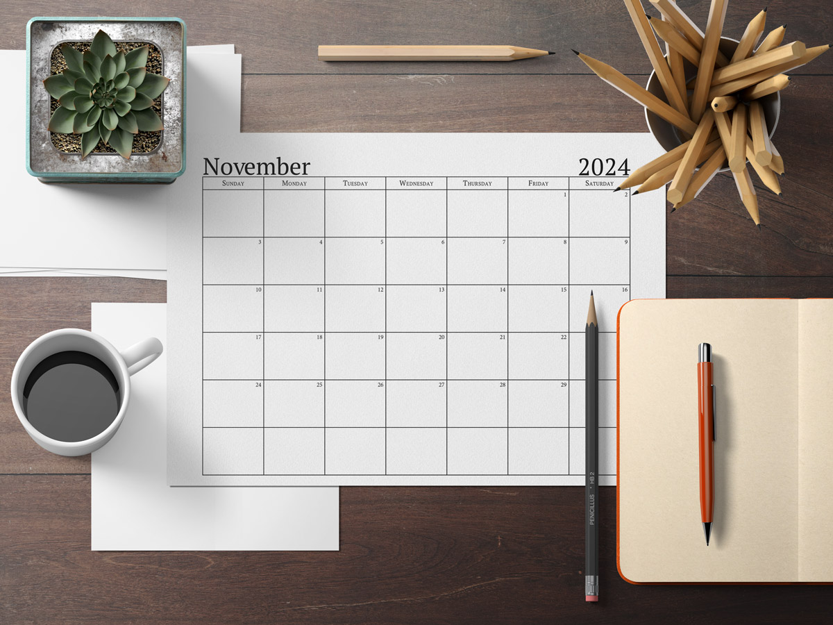 This image shows an example of the free 2024 calendar one page design you can get for free in this blog post. It's showing the month of November laying on a desk top.