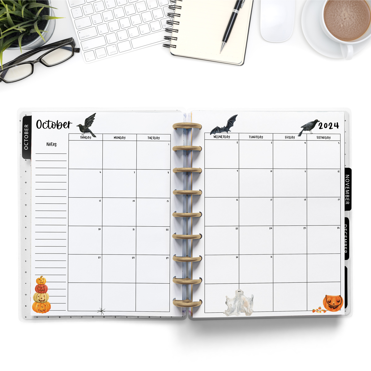 This image is an example of one of the printable 2024 calendar you can get for free at the end of this post. This is showing the month of October inside of an open planner. Above the planner is an open laptop keyboard, a notebook, a pencil, cup of coffee, a plant, and a pair of glasses.