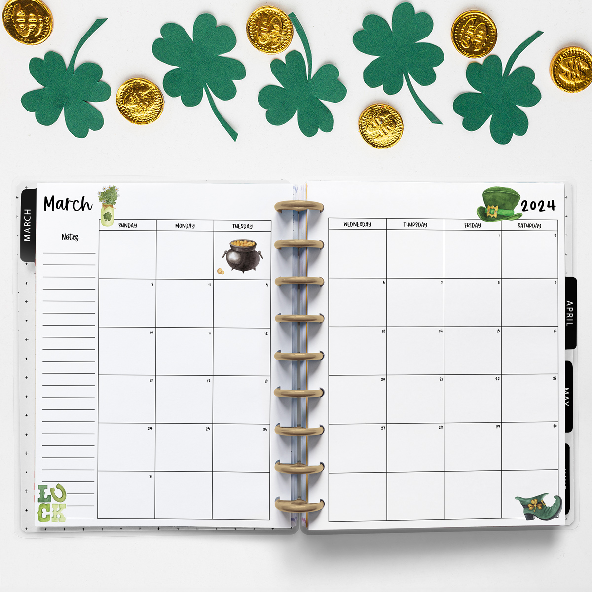 This image is an example of one of the printable 2024 calendar you can get for free at the end of this post. This is showing the month of March. Above the planner are some paper clovers and plastic fake coins.