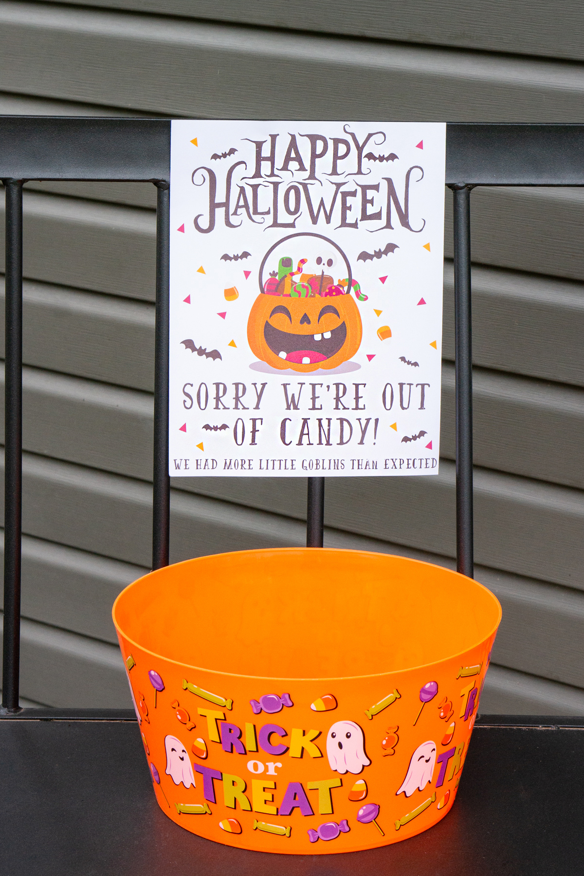 This image shows one of the free printable Halloween candy signs you can get in this free set. This sign says Happy Halloween. Sorry we're out of candy! There were more little goblins than we expected. Under the sign is a bowl of candy.