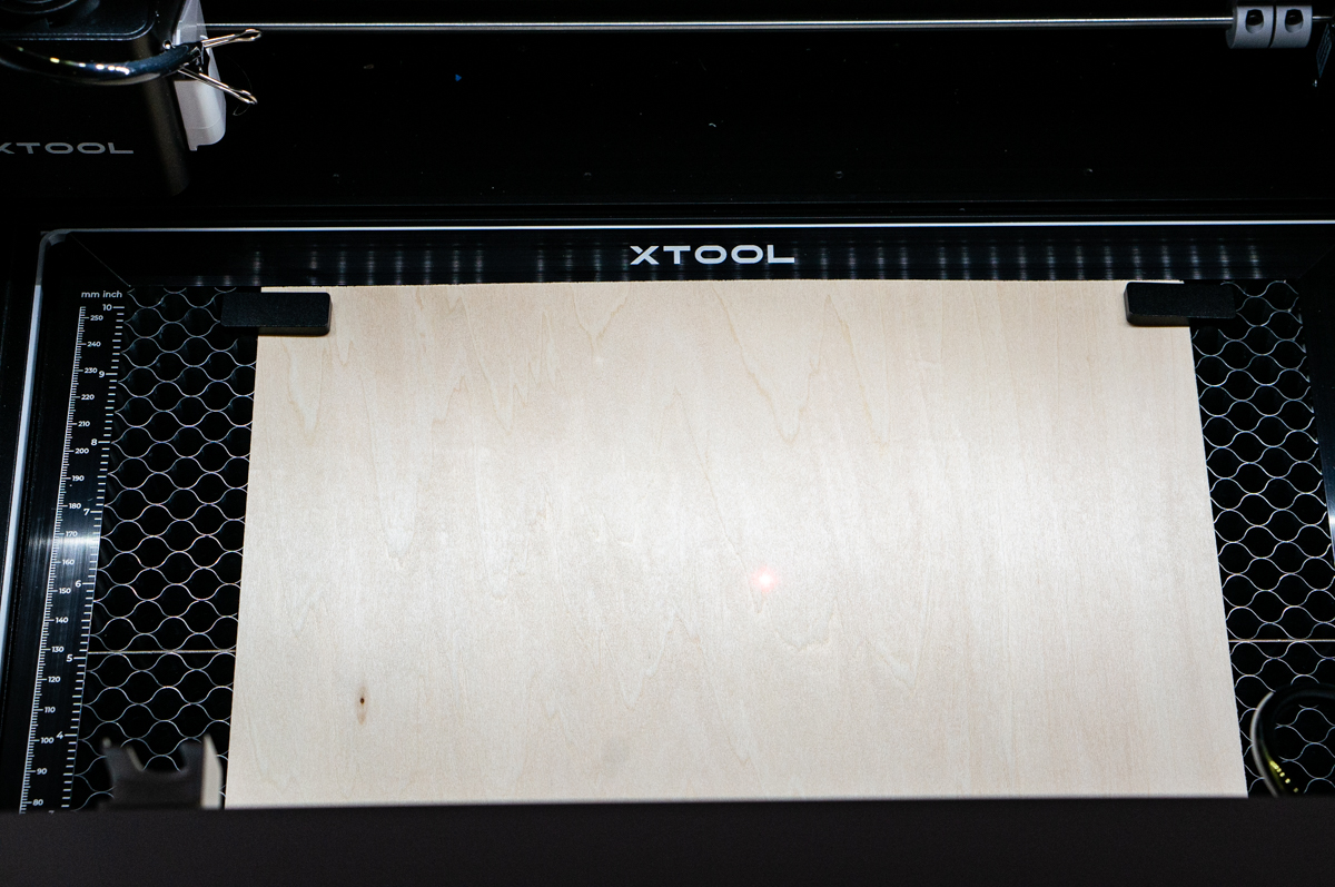 This image shows a piece of wood placed inside of an xTool M1 machine ready to be laser cut.