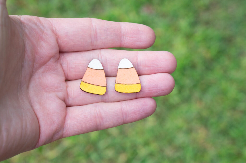 This image shows one of the pairs of earrings you can make using the Halloween earring SVG set. It's a pair of candy corn earrings.