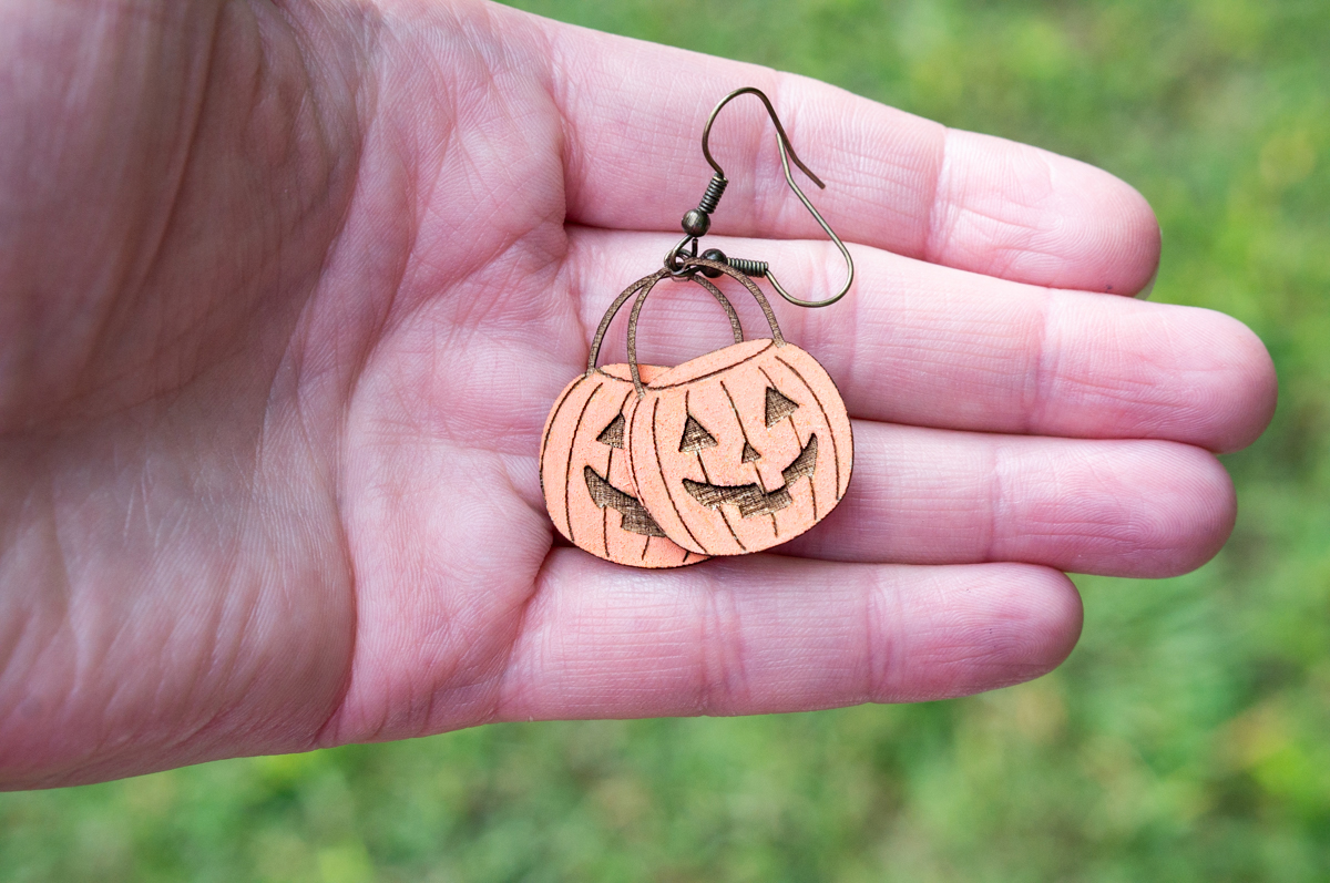 This image shows one of the pairs of earrings you can make using the Halloween earring SVG set. It's a pair of pumpkin buckets.