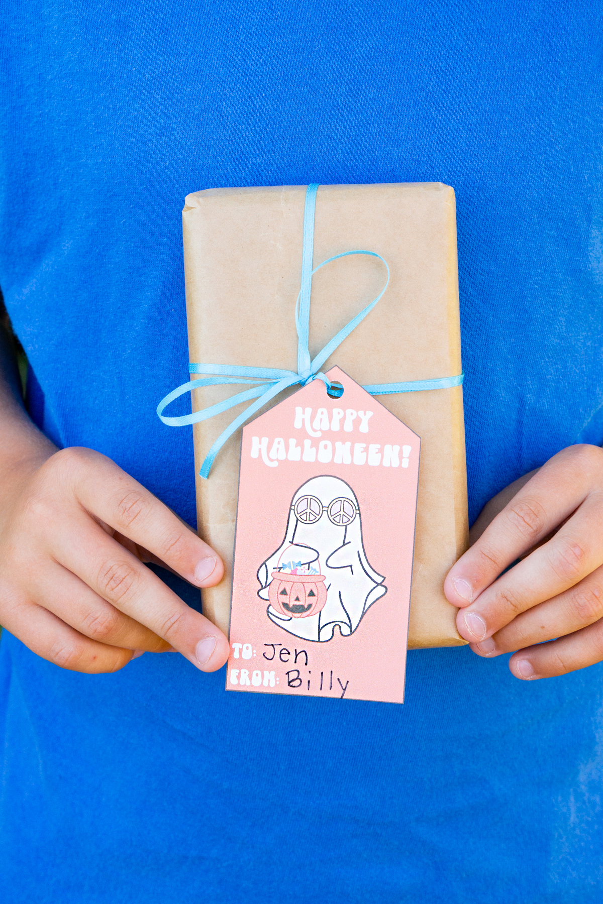 This image shows one of the free Happy Halloween printable tags tied onto a wrapped gift.