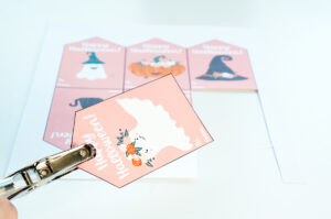 This image shows one of the free Happy Halloween printable tags being hole punched.
