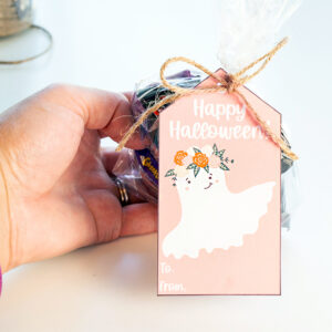 This image shows one of the free Happy Halloween printable tags tied onto a bag of candy.