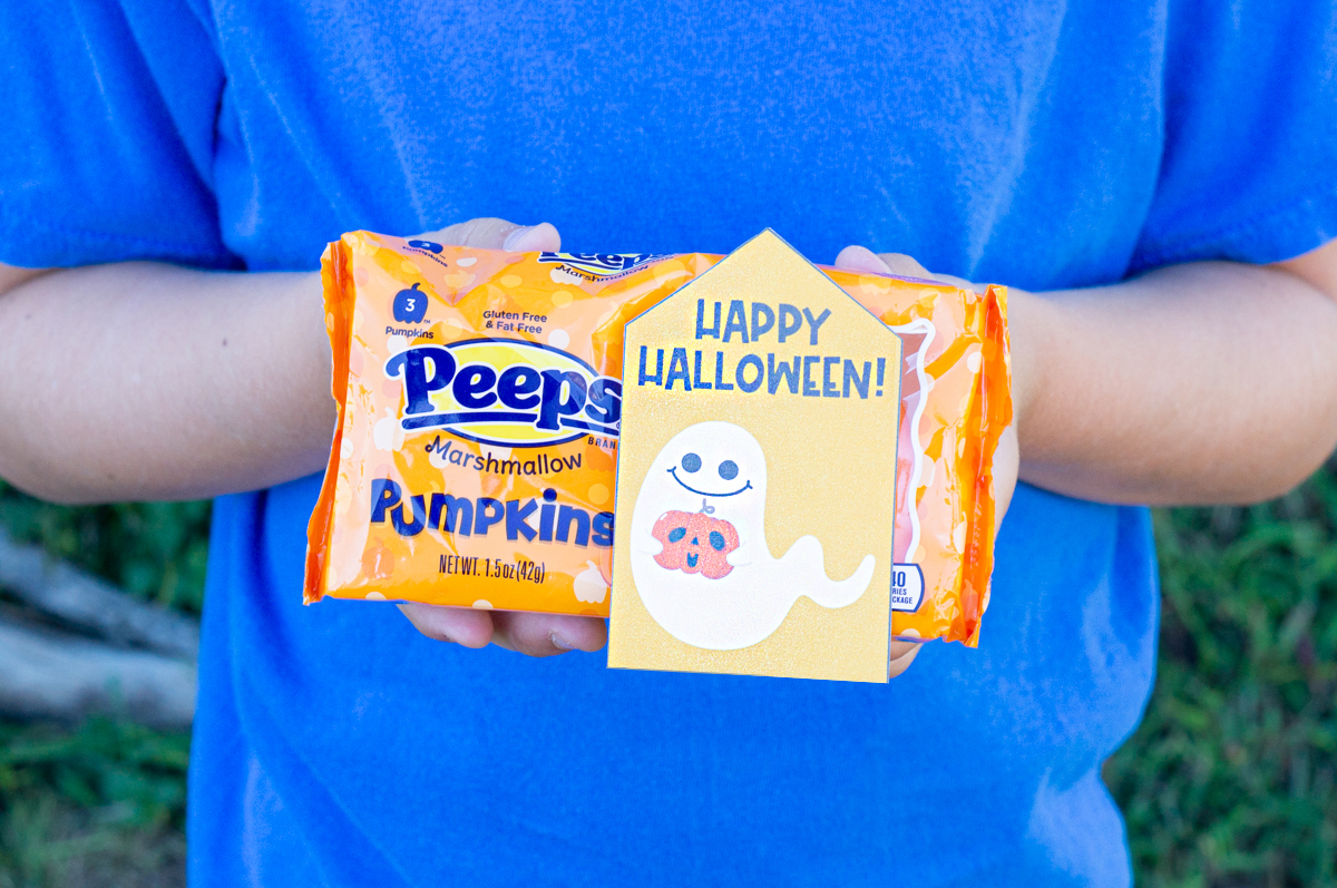 This image shows one of the free Happy Halloween printable tags taped onto a pack of Halloween peeps.