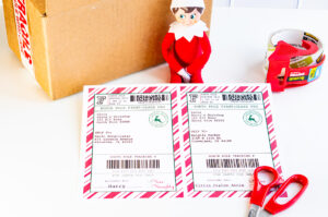 This image shows an example of the free Elf on the shelf mailing label you can download for free in this blog post. It has a picture of a box, an elf, scissors, packing tape, and 2 labels.