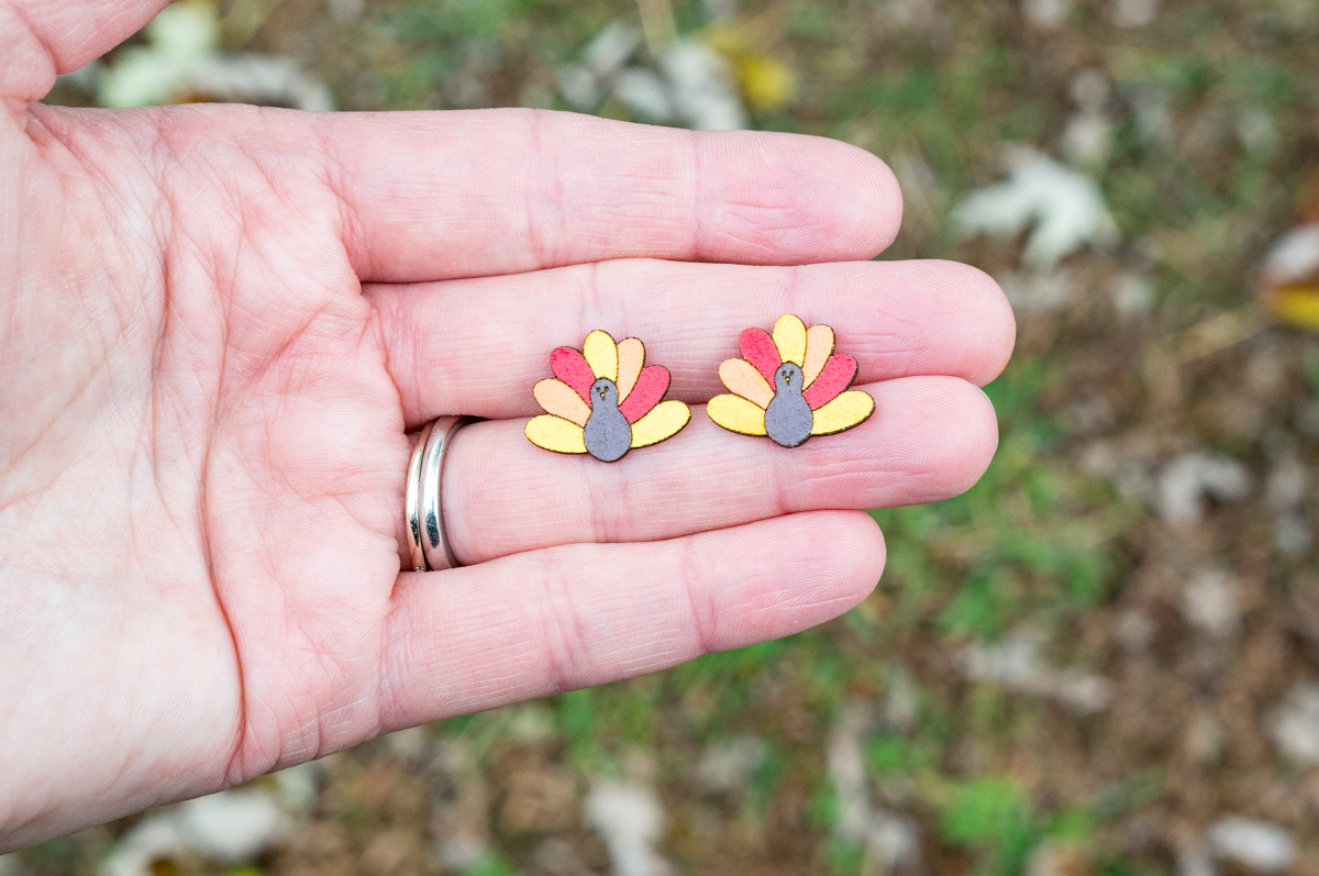 This shows the final cute turkey earrings made using the free Thanksgiving earrings SVG files.