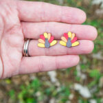 This shows the final cute turkey earrings made using the free Thanksgiving earrings SVG files.