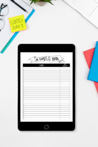 iPad displaying the &lsquo;26 Goals for 2026&rsquo; digital planner page on a white desk with glasses, sticky notes, books, and a plant.