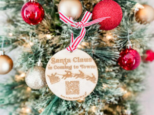 Learn how to make wooden ornaments with a laser using this adorable free Christmas Santa tracker ornament file. It says, "Santa Claus is coming to Town" and has a picture of Santa flying with his reindeer and a QR code to scan and visit the Santa tracker app.