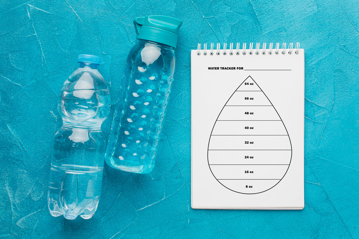 This image is an example of one of the water tracker printable options from the free printable water tracker set you can get for free in this blog post. It's next to two bottles of water.
