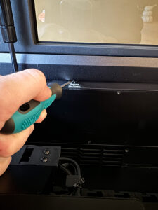 This is an image of unscrewing a screw in an xTool P2 laser machine.