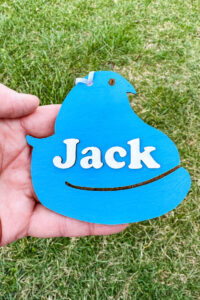 This image shows one of the Easter basket tags made out of wood using an xTool laser machine. It's in the shape of a blue peep chick with the name Jack on it.