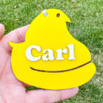 This image shows one of the Easter basket tags made out of wood using an xTool laser machine. It's in the shape of a peep with the name Carl.